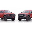 Two red lifted pickup trucks with custom front bumpers and roof lights displayed side by side