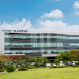 Hyundai Transys modern corporate headquarters building with glass facade and landscaped grounds under blue sky