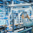 Female factory worker in safety gear photographing industrial equipment in modern manufacturing facility