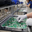 Electronics factory workers assembling and inspecting green circuit boards on an industrial production line