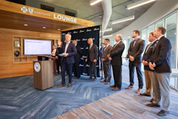 Business professionals gathered in South Carolina Lounge for corporate presentation at podium with display screen