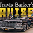 Travis Barker's classic black convertible cruiser displayed in showroom with two men standing beside the vintage 1950s car