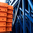 Orange and blue industrial warehouse racking system with metal shelving and structural beams