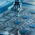 Precision drilling machine performing circuit board assembly with blue-toned industrial equipment