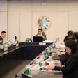 Formal business meeting with professionals seated at conference table in modern office setting
