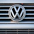 Volkswagen logo on wet vehicle grille with chrome trim