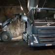 Volvo truck and wheel loader operating in an underground tunnel construction site with bright LED lighting